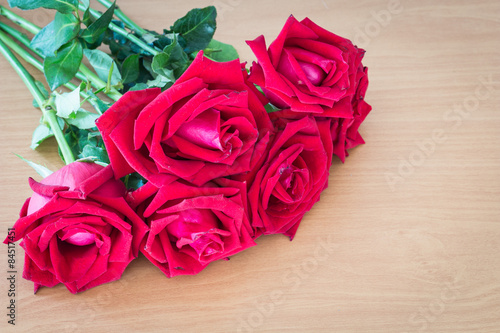 Red roses on wooden vintage table
