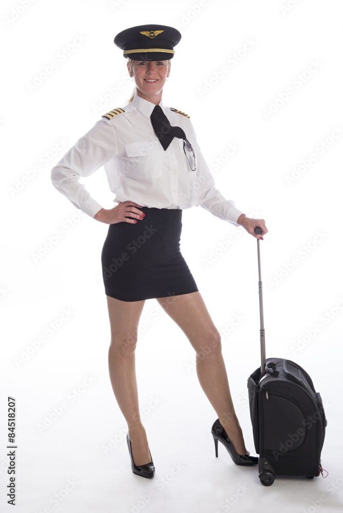 Attractive mid age female airline pilot in uniform with a carry on bag Attractive mid age female airline pilot in uniform with a carry on bag