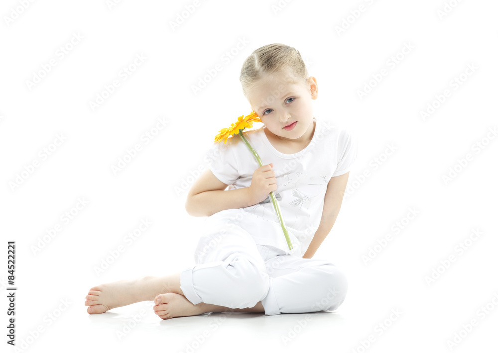 very cute girl sitting on a white floor holding flowers very cute girl sitting on a white floor holding flowers