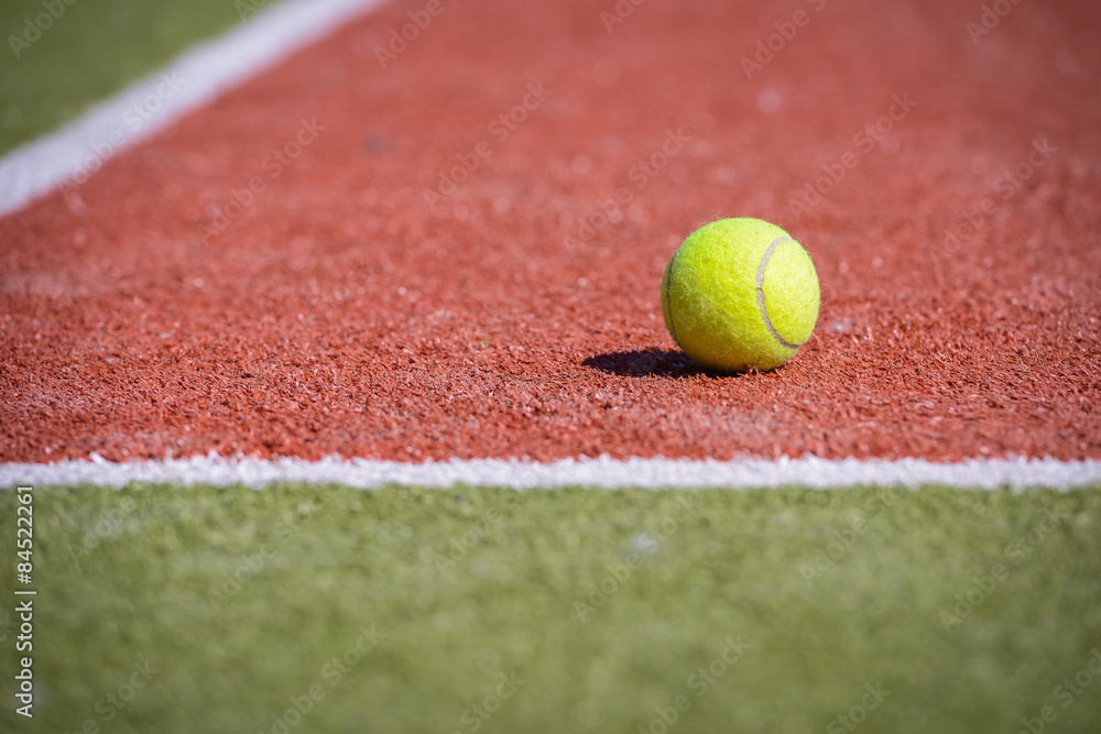Теннисный мяч на оранжево-зеленом поле