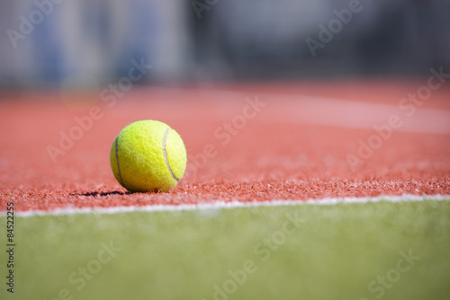 Теннисный мяч на оранжево-зеленом поле