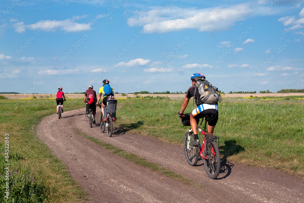 Fototapeta Group of tourists mountain bike ride on dirt road.