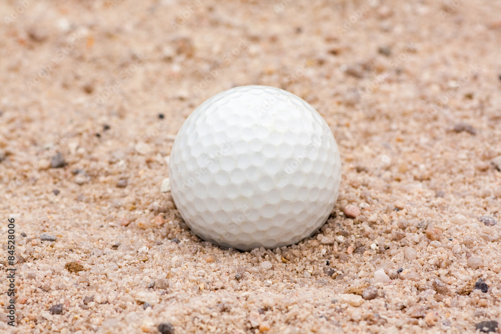 Used golf ball lying in sand bunker. Used golf ball lying in sand bunker.