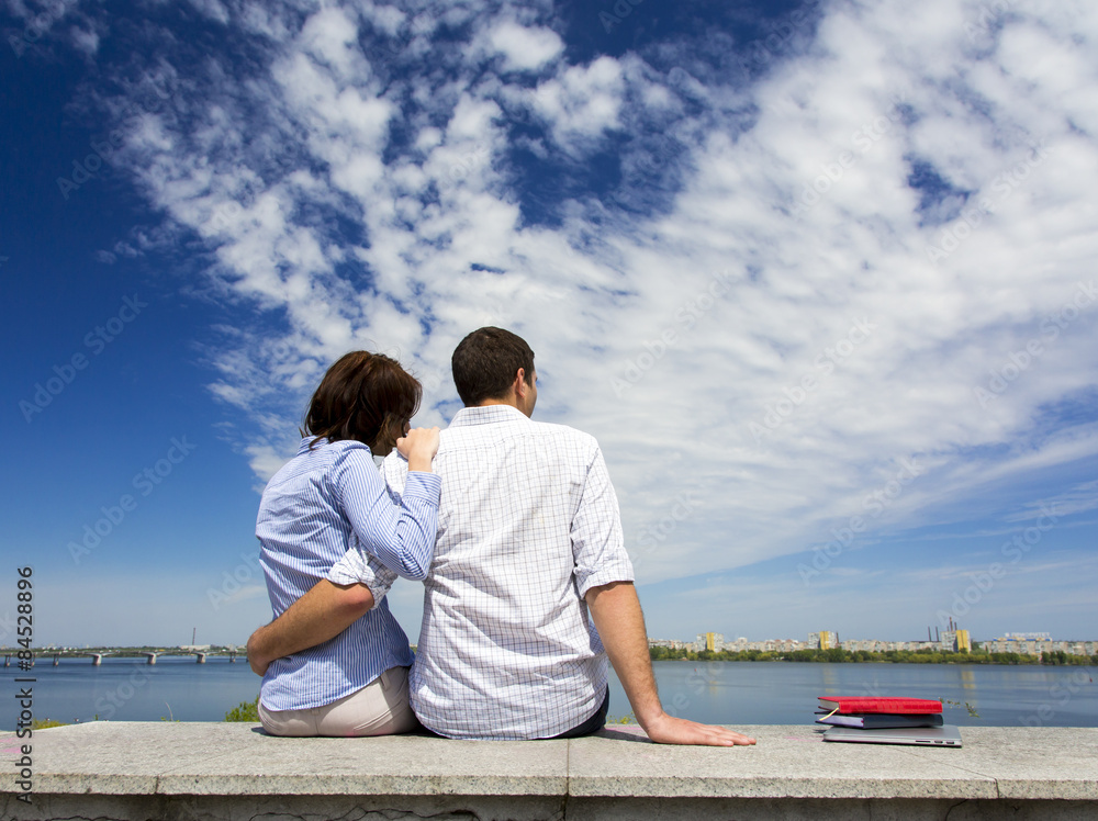 Young couple and cloudy sky
