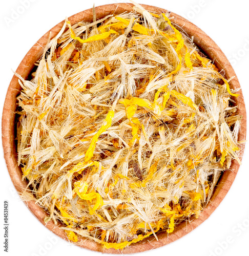 Mountain arnica in a small  wooden bow isolated on white. photo