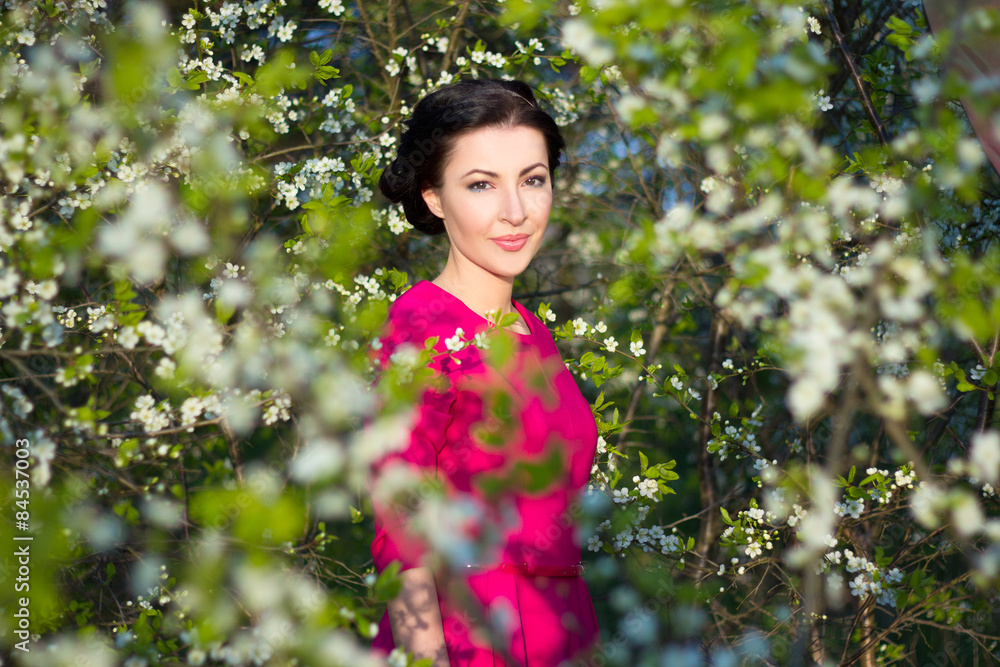 young beautiful brunette woman standing near the cherry tree young beautiful brunette woman standing near the cherry tree