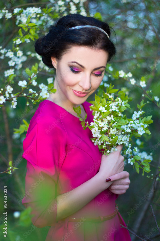 portrait of beautiful brunette woman in pink dress in blooming c portrait of beautiful brunette woman in pink dress in blooming c