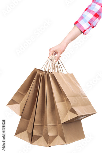 Female hand holding paper shopping bag isolated on white © Africa Studio