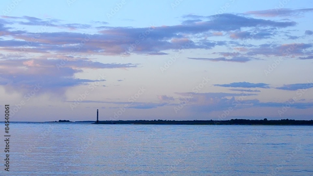 Colorful clouds, lighthouse and water at sunset Colorful clouds, lighthouse and water at sunset