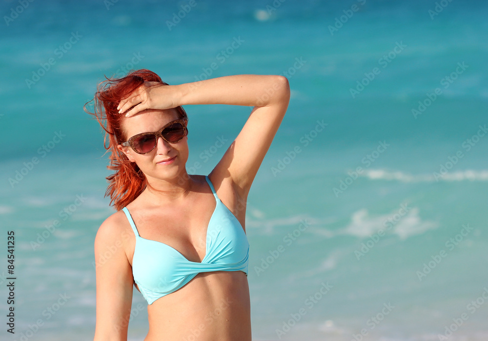 The redhead young woman standing in the ocean water The redhead young woman standing in the ocean water