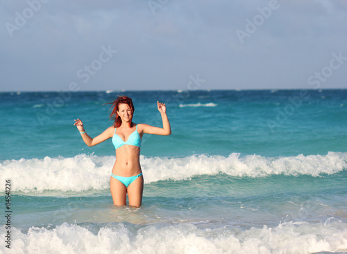 The redhead young woman standing in the ocean water
