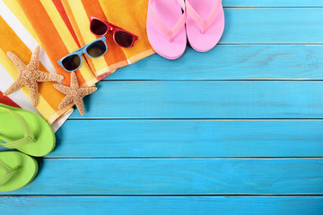 Beach background border scene with old blue wood deck decking sunglasses and sunbathing towel summer holiday vacation photo