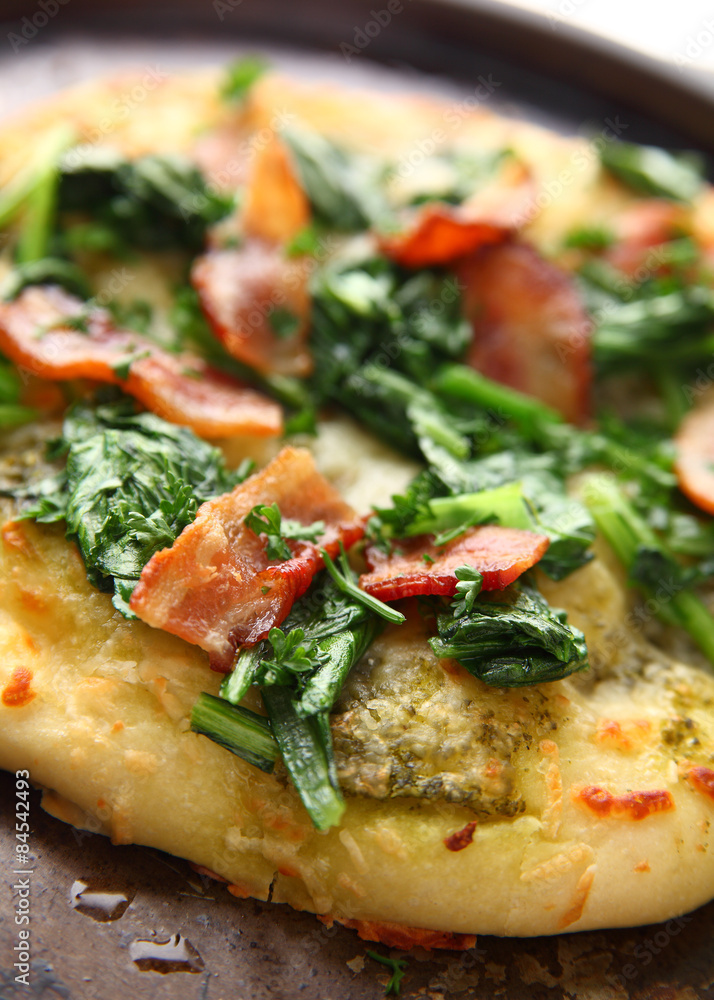 Closeup of pizza topped with bacon and greens Closeup of pizza topped with bacon and greens