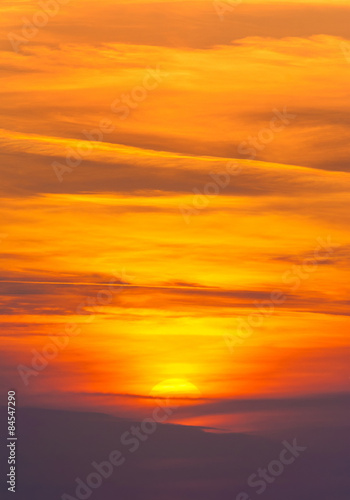 Bright sunset in cirrus fiery clouds - vertical nature backgroun