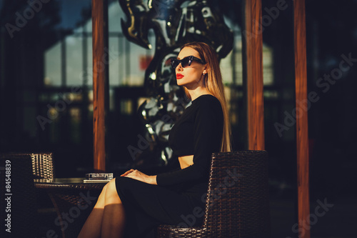 fashionable girl sitting in a cafe looking away