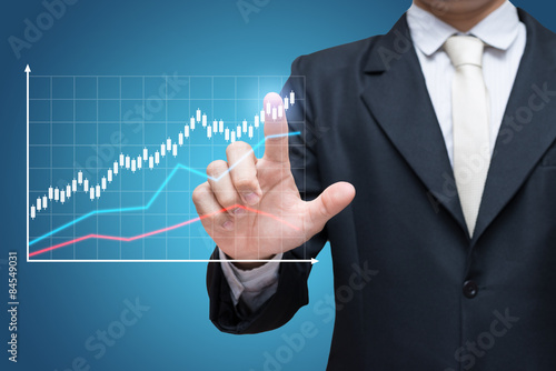 Businessman standing posture hand touch graph finance isolated on blue background