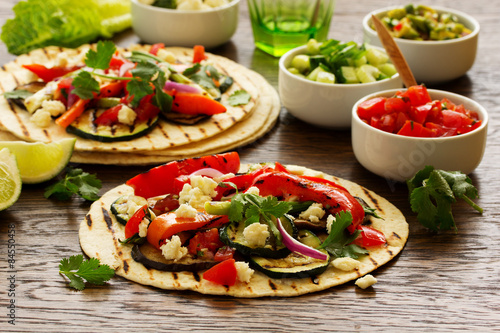 Vegetarian snack tacos with grilled vegetables and salsa.