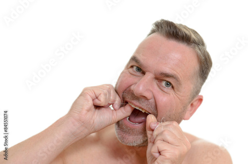 Mann benutzt Interdental-Büste zur Zahnreinigung
