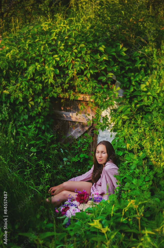 Tender woman resting in grassy thickets with a beautiful bouquet Tender woman resting in grassy thickets with a beautiful bouquet
