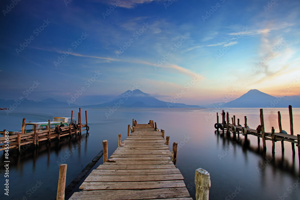 Colorful sunset at the Panajachel Pier with volcanoes in the background, Lake Atitlan, Guatemala, Central America - obrazy, fototapety, plakaty 