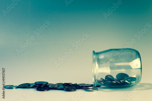 Money and banking concept with coins and jar.