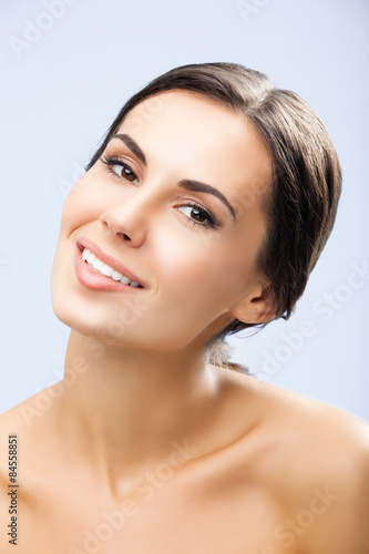 Portrait of beautiful smiling woman, on grey