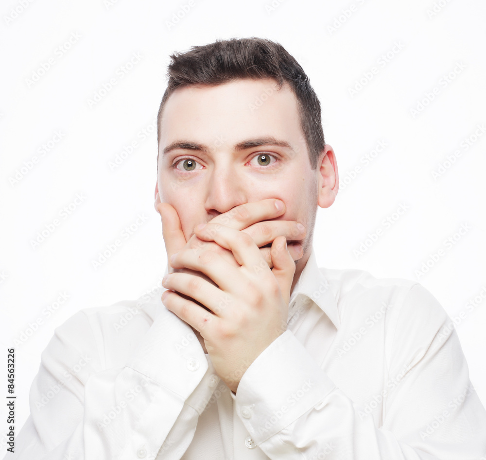 Shocked young man covering mouth with hands Shocked young man covering mouth with hands