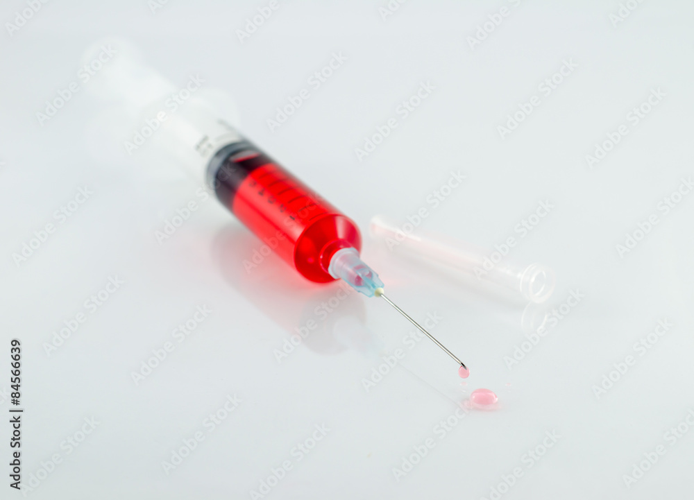 Medical syringe with drop on white background Medical syringe with drop on white background