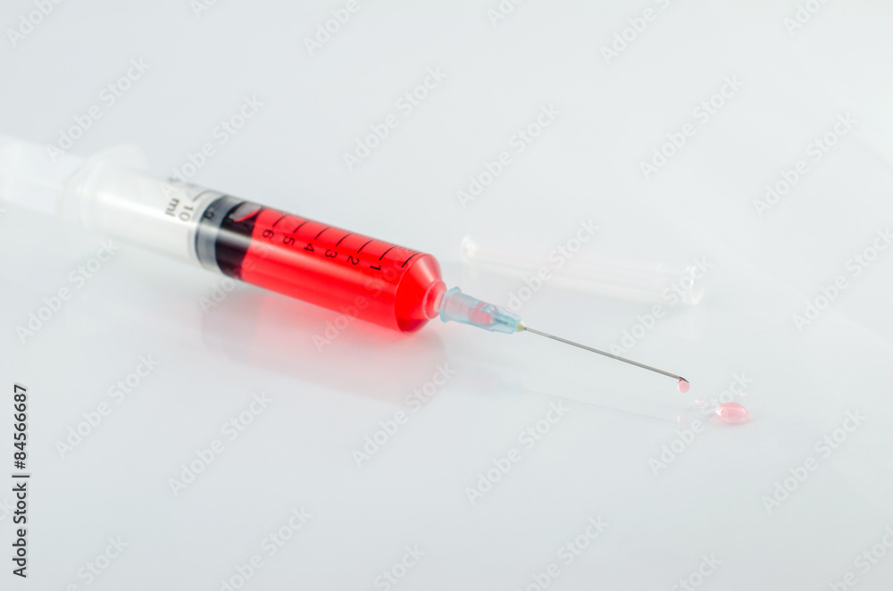 Medical syringe with drop on white background Medical syringe with drop on white background