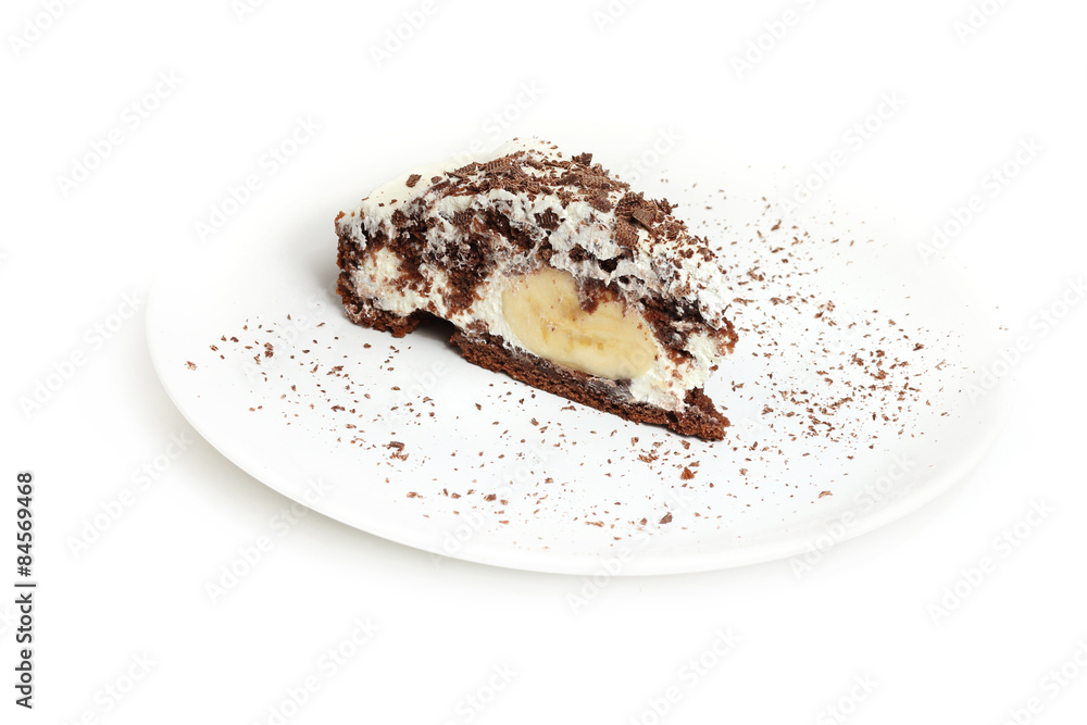 Fototapeta premium Piece of banana and chocolate cake on porcelain plate. Isolated on white