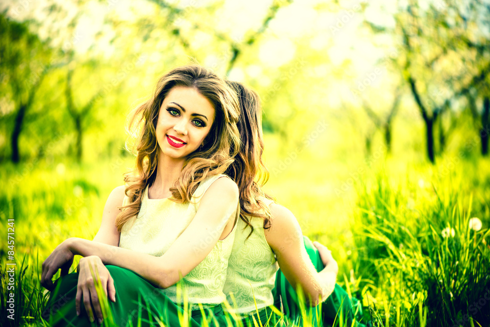 Two happy pretty girls sitting on the green grass Two happy pretty girls sitting on the green grass