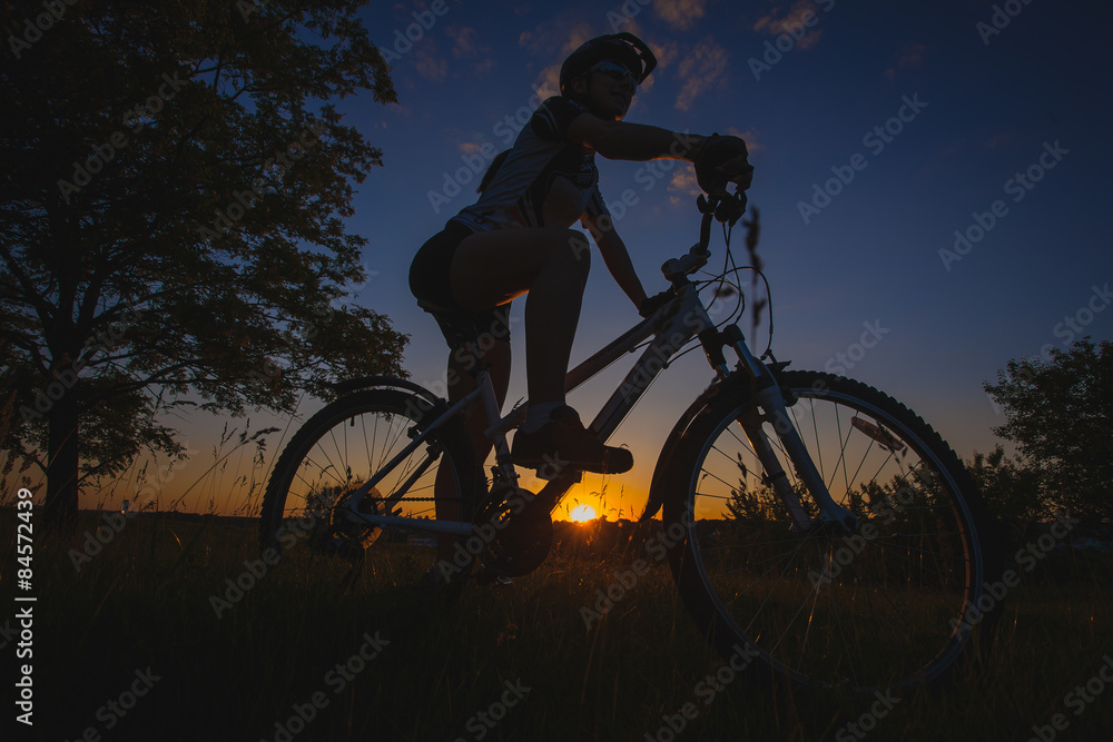 Fototapeta premium cyclist riding bike at sunset