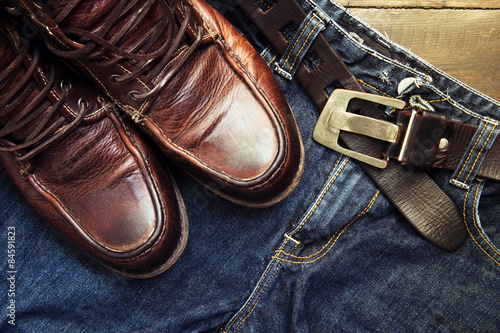 Jeans belt and shoes set on wood