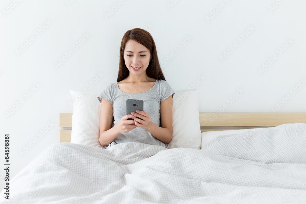 Woman using cellphone in living room Woman using cellphone in living room