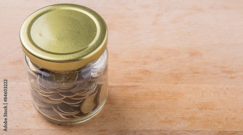 Malaysian coins in a mason jar over wooden background Malaysian coins in a mason jar over wooden background