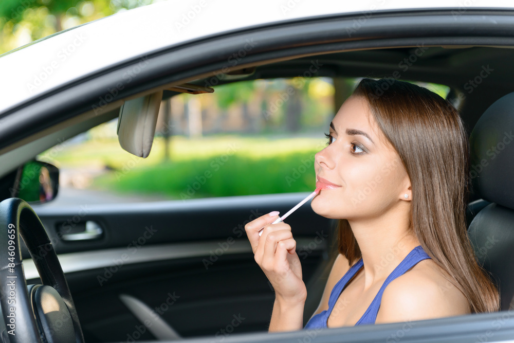 Woman doing makeup inside car