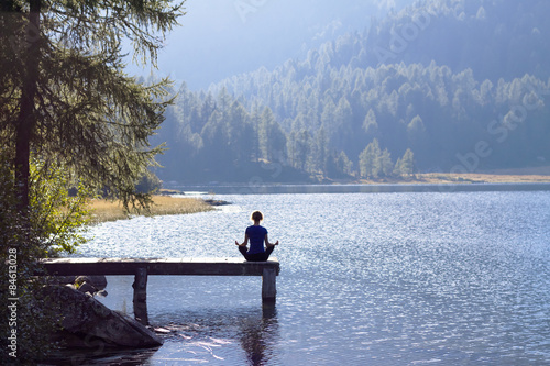 Woman doing yoga at lake