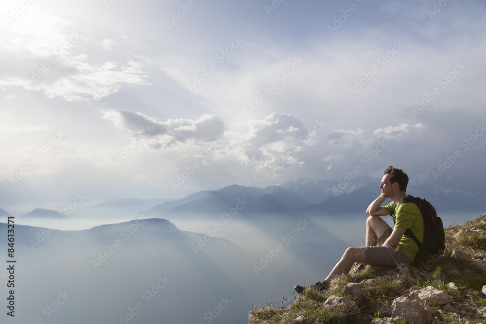 Hiker sitting to view beautiful landscape Hiker sitting to view beautiful landscape