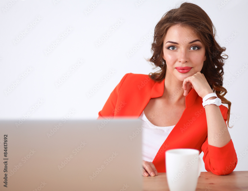 Attractive woman sitting at desk in office, working with laptop Attractive woman sitting at desk in office, working with laptop