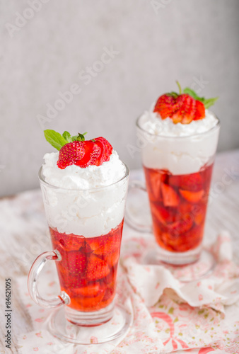 Strawberries in jelly topped with whipped cream