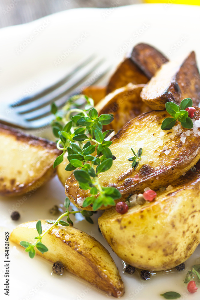 Baked new potatoes with herbs on a wooden background