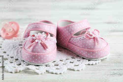 Pink toddler shoes on wooden background
