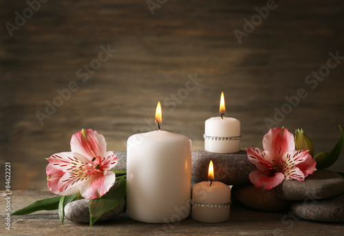 Beautiful composition with candles and spa stones on wooden background