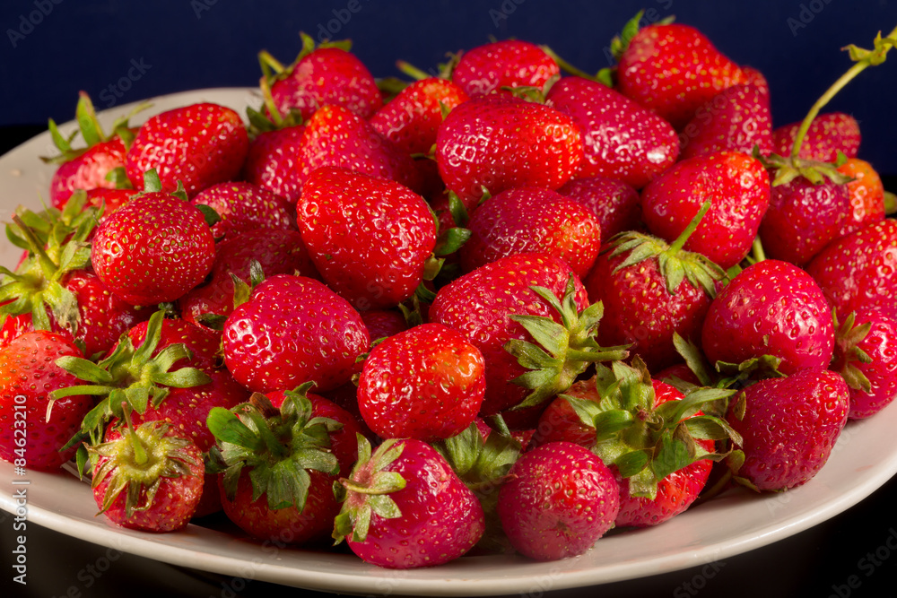 Close up of juicy garden strawberries on a white plate Close up of juicy garden strawberries on a white plate