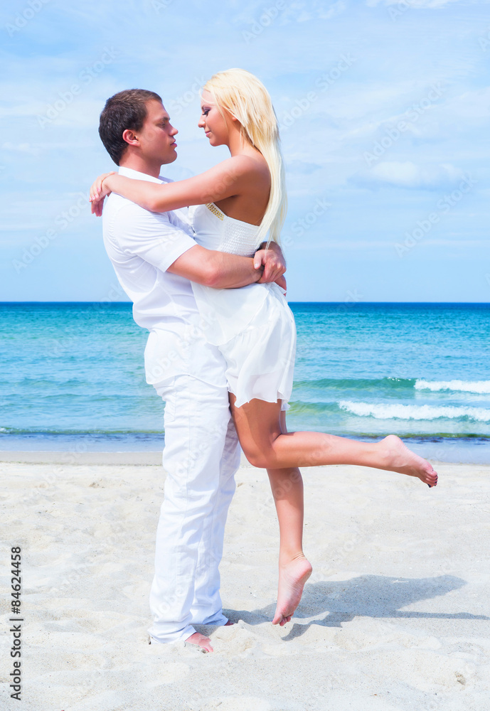 Loving couple walking and embracing on a tropical summer beach Loving couple walking and embracing on a tropical summer beach