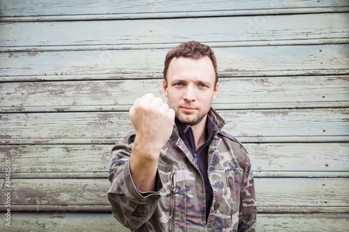 Caucasian man in camouflage showing his big fist