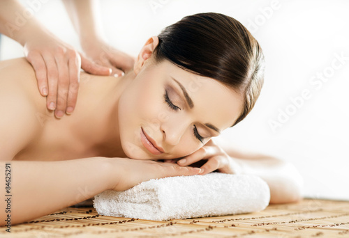 Young and healthy woman in spa salon. Traditional Swedish massage therapy and beauty treatments.