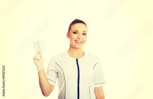Portrait of female dentist holding a tooth model