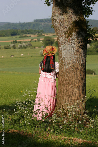 Femme appuyée sur un arbre dans la campagne
