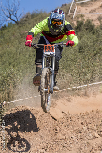 Downhill competition, Biker jumps fast in the countryside.